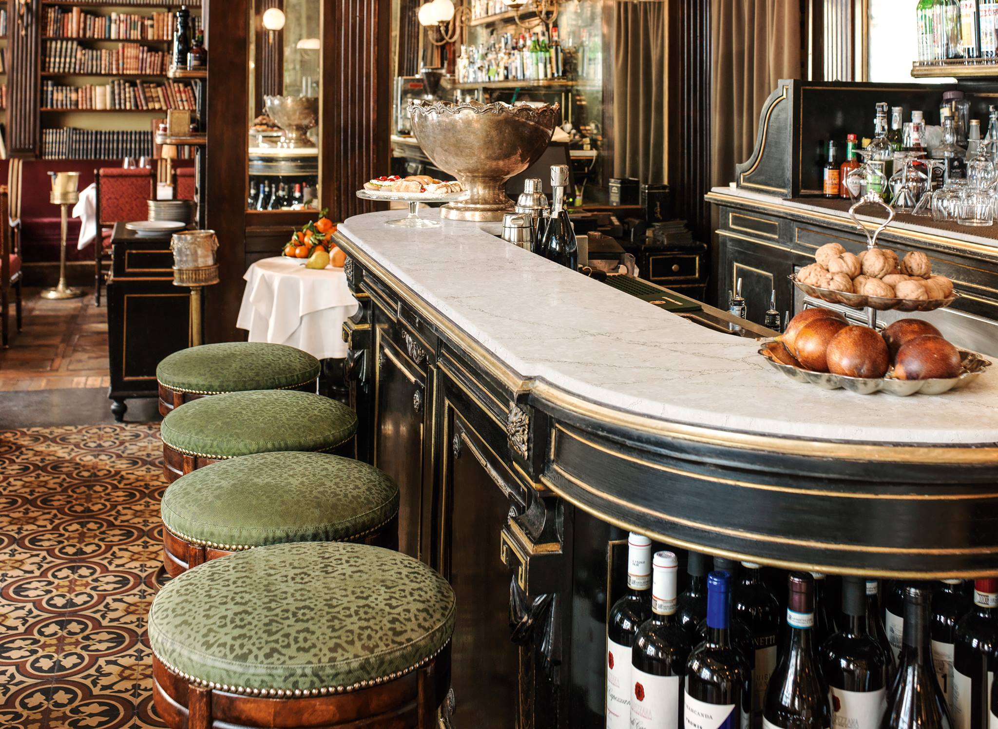 A stylish bar with a sleek counter, adorned with an array of colorful bottles and a warm, welcoming ambiance.