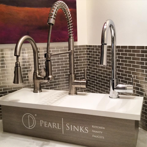 A kitchen sink featuring two faucets and a central sink faucet, showcasing a modern and functional design.
