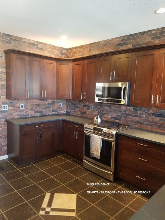 A kitchen showcasing rich brown cabinets and dark tile flooring.