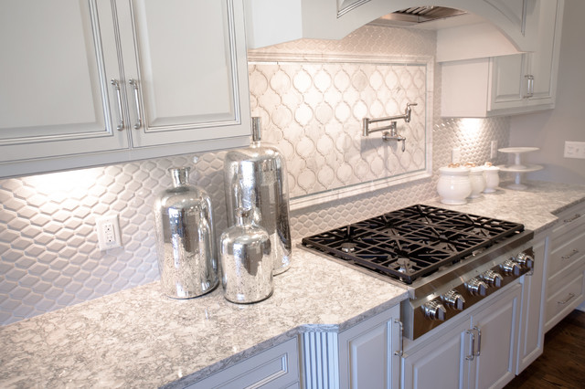 A bright kitchen featuring white cabinets and a sleek stove top